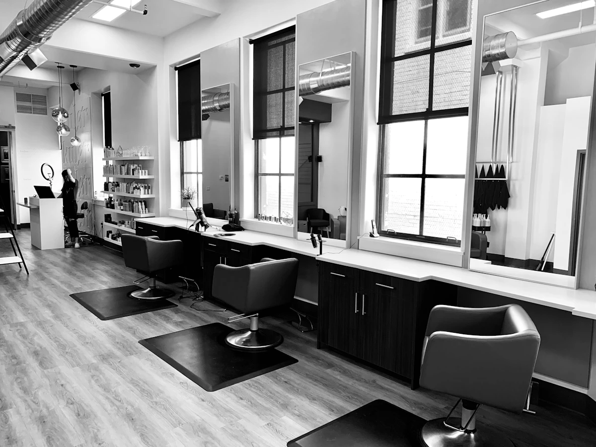 Profissional cuidando do cabelo de uma cliente em salão elegante